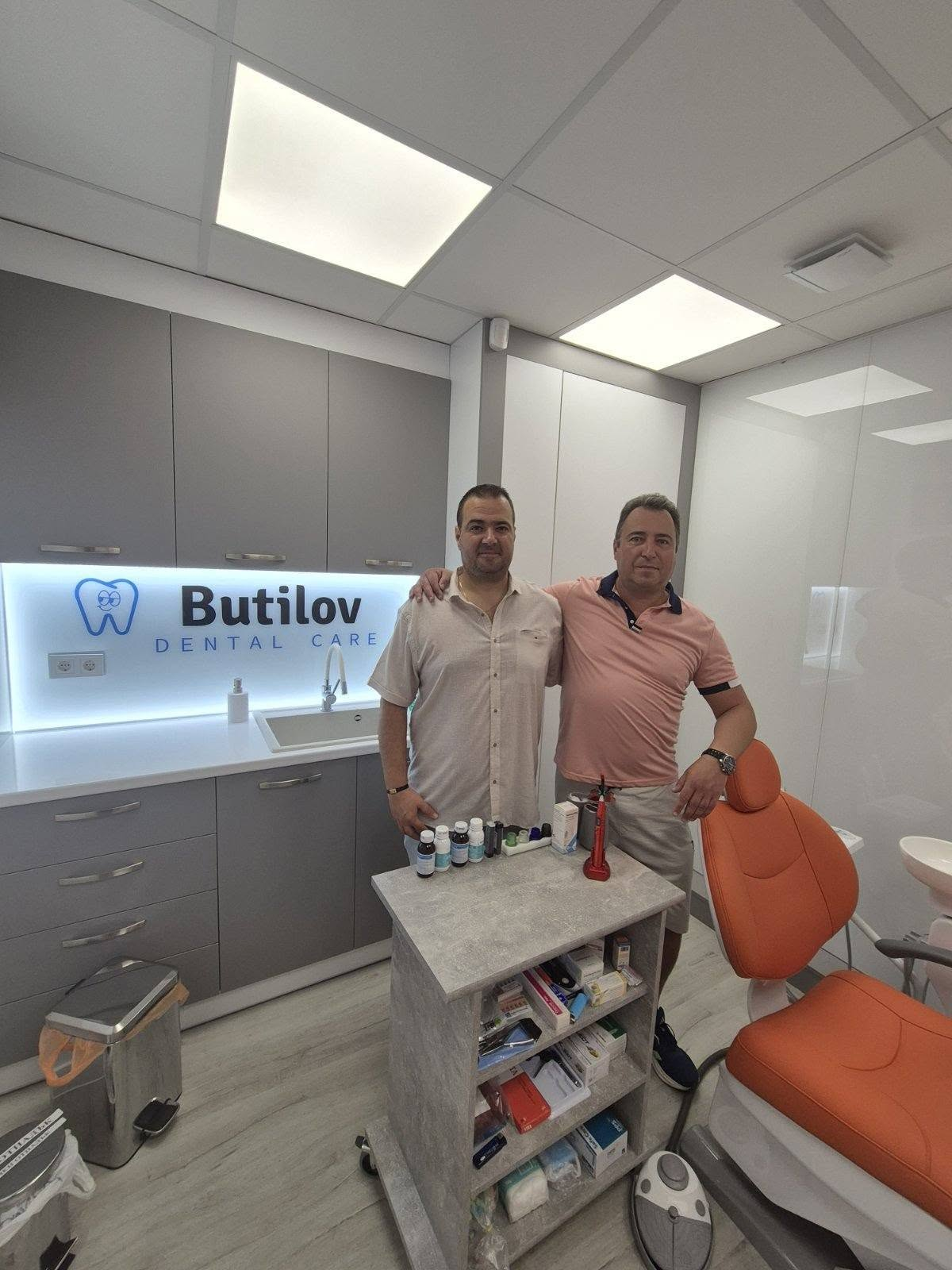 Д-р Калин и д-р Любомир Бутилов заедно в кабинета пред логото Butilov Dental Care